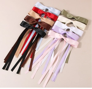 Assorted colorful satin ribbon bow hair clips with long tails in multiple vibrant shades