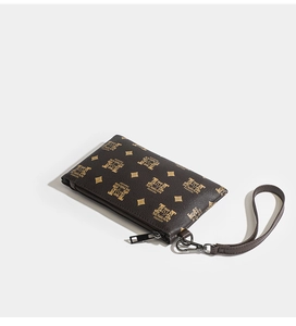 Detail of dark brown lychee grain PU leather clutch with wristlet and gold monogram