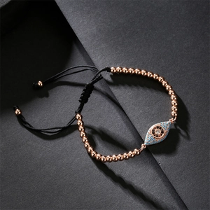 Macro shot of rose gold evil eye bracelet with blue micro-pave zircons and woven strap