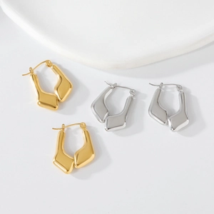 Detailed view of irregular geometric earrings in polished gold and silver finishes
