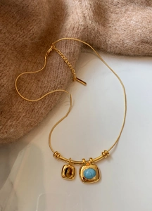 Détail du collier oeil de tigre plaqué or 18 carats avec pendentifs carrés bicolores