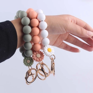 Silicone daisy beaded wristlet keychain set in dark green, coral pink, and white colors