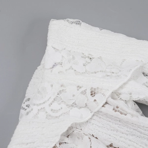 Close-up detail showing the intricate white lace embroidery and fabric texture of the dress