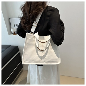 Detail of a large capacity off-white canvas tote bag with adjustable wide shoulder strap