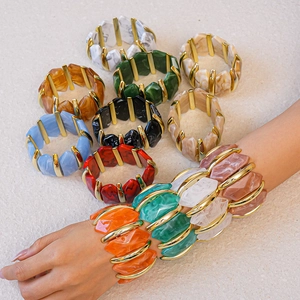 Gros plan sur les bracelets géométriques en résine acrylique avec texture marbre et métal