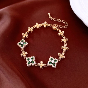 Macro detail of the adjustable 18K gold plated flower bracelet with green gems on silk