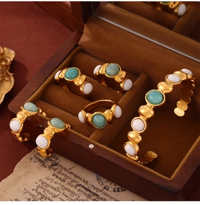 Detail of vintage gold plated jewelry set with green stones in a wooden box