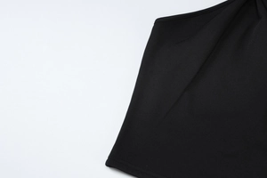 Détail rapproché des coutures de haute qualité et de l'ourlet sur un haut noir