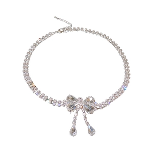 Elegant silver necklace with rhinestone bow design and teardrop crystal pendants on white background