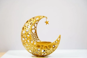 Detail of golden hollow crescent moon and star metal candle holder with intricate patterns