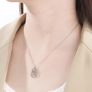 Gros plan d'un collier avec pendentif nœud argenté et cercle creux porté par un mannequin