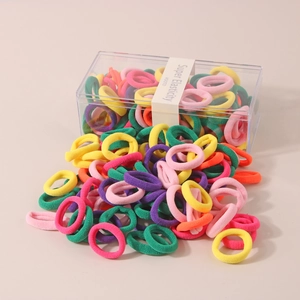 Vibrant multi-colored elastic hair bands spilling from a clear storage box