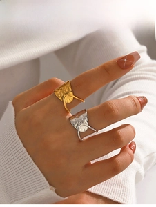 Detail view of gold and silver crossover rings with unique hammered texture design