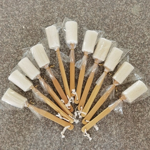 Detail view of long wooden handle loofah back scrubbers in individual plastic packaging