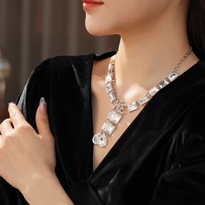 Macro shot of luxury square and pear-cut crystal necklace on model's neck