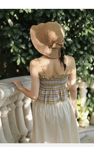 Detalle del sombrero de paja con un elegante lazo en la parte trasera para un look casual
