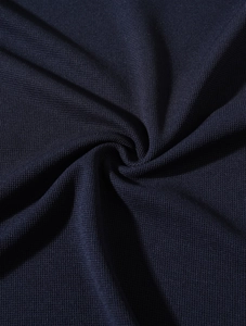 Macro shot of breathable dark blue pique knit fabric showing premium texture and weave
