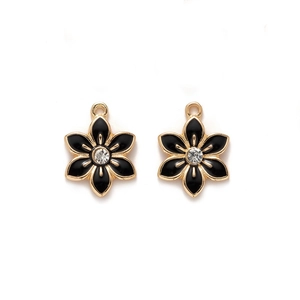 Close-up of golden alloy flower pendant with black enamel finish and central clear rhinestone
