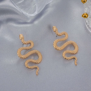 Vintage gold snake-shaped earrings with scale texture on light gray silk background