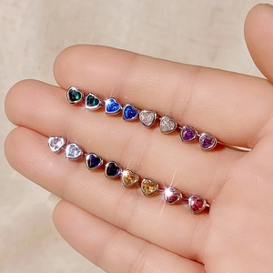 Detailed view of colorful heart-shaped zircon stones set in silver metal jewelry