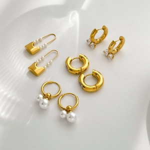 Gold titanium earrings set with pearls and cubic zirconia in various sweet heart designs