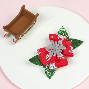 Detail of Christmas glitter bow hair clip with snowflake sequins on white tray