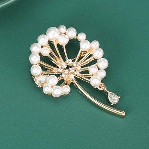 Détail d'une broche pissenlit avec perles et strass sur fond vert texturé élégant