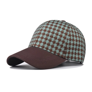 Detailed side view of houndstooth baseball cap with brown brim and vintage plaid pattern