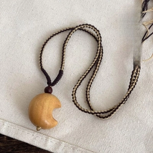 Bohemian woven rope necklace with a smooth wooden crescent moon and star pendant charms