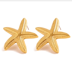 Vue macro détaillée des boucles d'oreilles étoile de mer dorées avec texture réaliste
