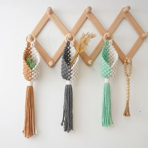 Three boho macrame hanging planters in brown, grey, and green with cotton rope tassels
