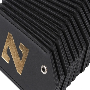 Close-up of black leather luggage tag featuring a gold embossed letter N and stitched edges