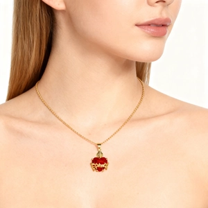 Sacred heart necklace with red heart zircon and golden thorn frame on a model