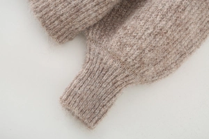 Close-up of oatmeal alpaca knit sweater showing premium fuzzy texture and ribbed cuff detail