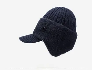 Detail of dark blue knitted winter hat featuring ear flaps and side decorative buttons