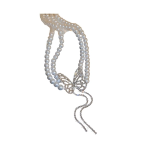 Double-layered pearl necklace with diamond butterfly pendant and elegant tassel fringe