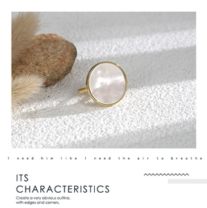 Detail of a minimalist gold ring featuring a large round iridescent white shell inlay