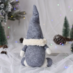 Nahaufnahme der grauen Weihnachtswichtel-Puppe aus Filz mit weißem Plüsch und Pinienzapfen