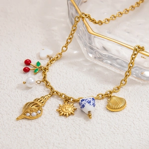 Detailed view of 18k gold plated starfish, shell and cherry charms on handmade chain
