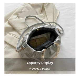Top view of silver pleated bag interior showing large capacity and pearl handle detail