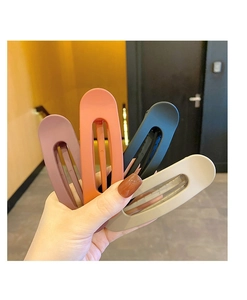 Set of four matte hollow rectangular hair clips in assorted colors held by a model