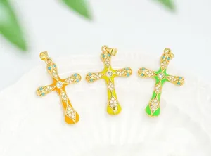 Macro view of three colorful enamel cross pendants with 18K gold plating and zircons