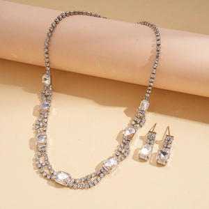Elegant silver necklace and earring set with square rhinestones on pink display