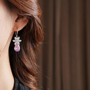 Détail de la boucle d'oreille avec goutte rose et fleurs en zircon sur mannequin