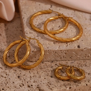 Three sizes of 18K gold plated stainless steel twisted rope hoop earrings on stone