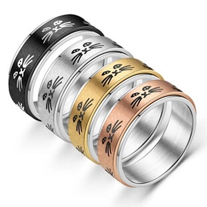 Detail of four stainless steel rings in black, silver, gold, and rose gold with cat face engraving
