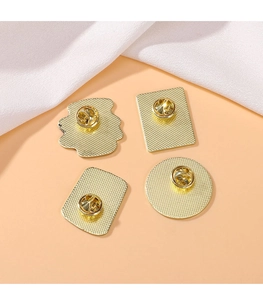 Detail view of four gold-plated alloy badge bases with standard butterfly clutch pin backs