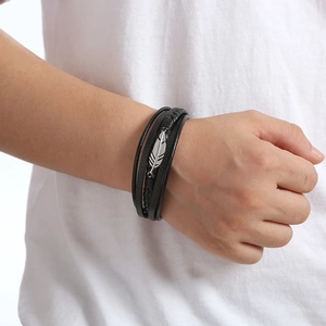 Men's multilayer black braided leather bracelet with silver feather pendant detail