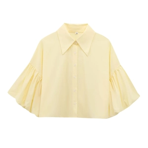 Detail of light yellow shirt collar with M size tag and puff sleeve tailoring