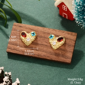 Detail of vintage heart earrings with colorful zircons on a festive holiday backdrop